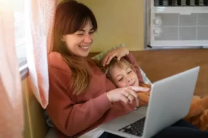 mujer-sonriente-de-tiro-medio-y-nino-con-computadora-portatil