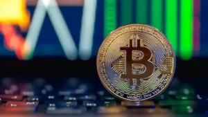 moneda-de-oro-de-bitcoin-en-el-teclado-grafico-de-negociacion-del-mercado-de-valores-candelabro-en-linea